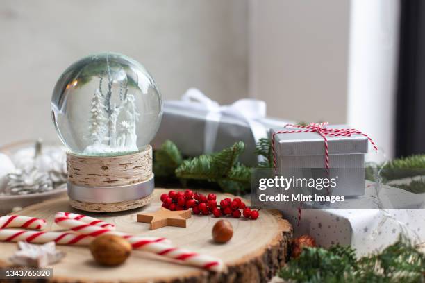 christmas decorations, a snow globe and presents and star shaped biscuits. - picture snow globe stock pictures, royalty-free photos & images