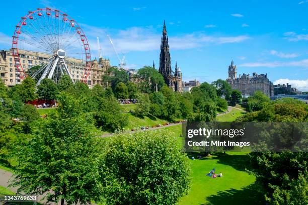 ferris wheel and scott monument in park in edinburgh. - edimburgo - fotografias e filmes do acervo