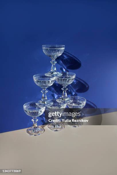 pyramid of champagne glasses with water on the beige-blue background - champagne pyramid stockfoto's en -beelden