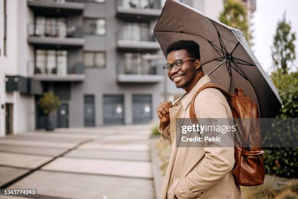 jeune homme d’affaires bien habillé avec parapluie à l’extérieur - bâtiment vu de lextérieur photos et images de collection