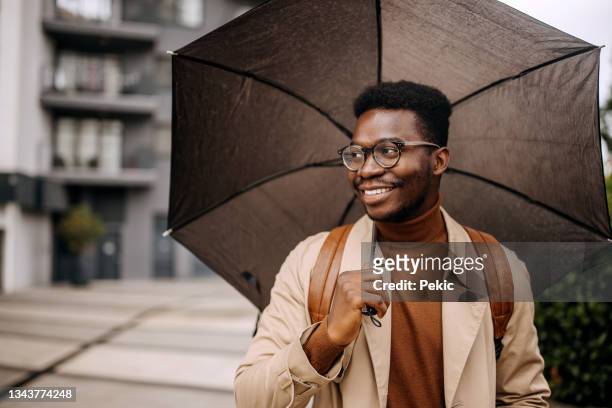 young well dressed businessman with umbrella outdoors - fashionable glasses stock pictures, royalty-free photos & images