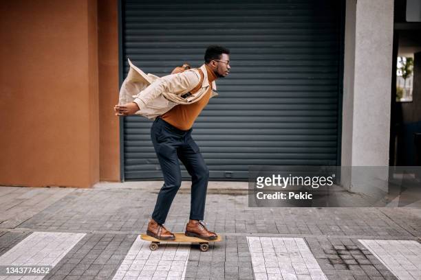 young handsome businessman driving skateboard on the city street - skateboard bildbanksfoton och bilder
