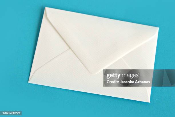 white envelope over turquoise background - kuvert bildbanksfoton och bilder