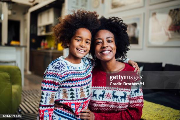 portrait of a happy african american mother spending winter holidays at home with her daughter - happy holidays family stock pictures, royalty-free photos & images