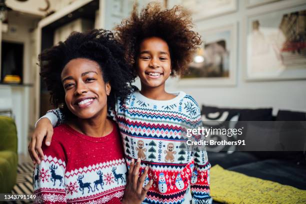 portrait of a happy african american mother spending winter holidays at home with her daughter - happy holidays family stock pictures, royalty-free photos & images