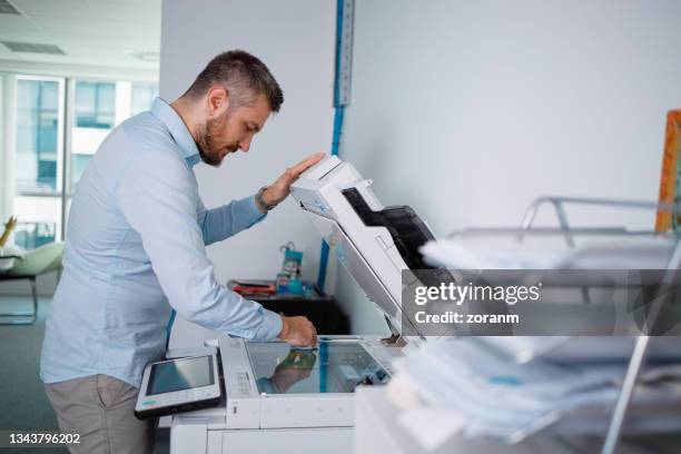 man cleaning photocopier glass before making copies - copying bildbanksfoton och bilder