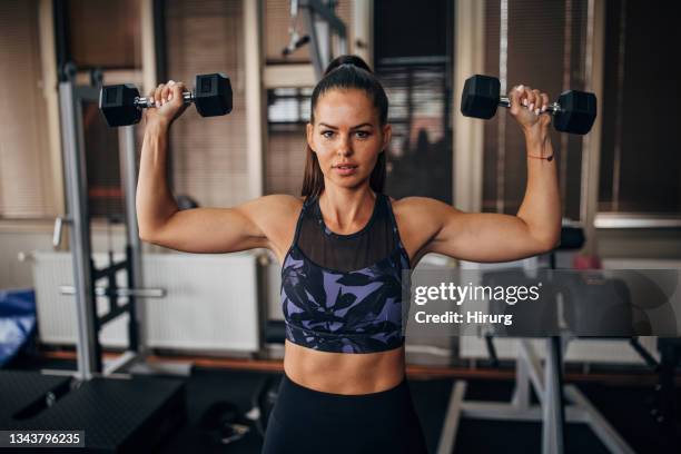 fit woman training with dumbbells - images of female bodybuilders stock pictures, royalty-free photos & images