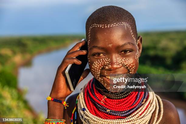 young girl from karo tribe using a smart phone, ethiopia, africa - african tribal face painting 個照片及圖片檔