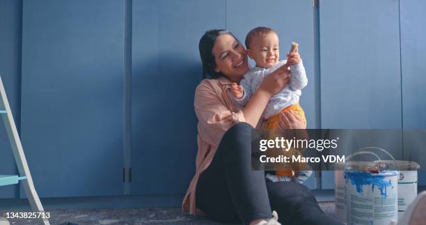 aufnahme einer frau, die mit ihrem sohn in einem raum sitzt, der renoviert wird - baby paint stock-fotos und bilder