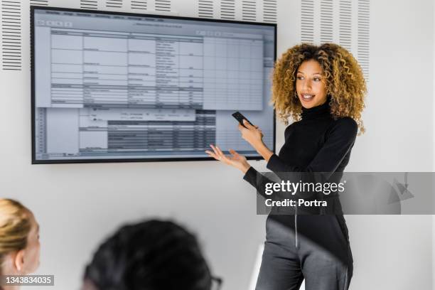 female professional sharing new project details in team meeting - business woman pointing stock pictures, royalty-free photos & images