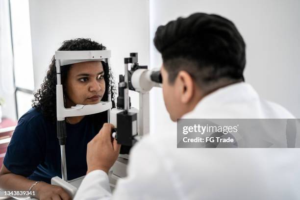 ophthalmologist examining patient's eyes - hoornvlies stockfoto's en -beelden