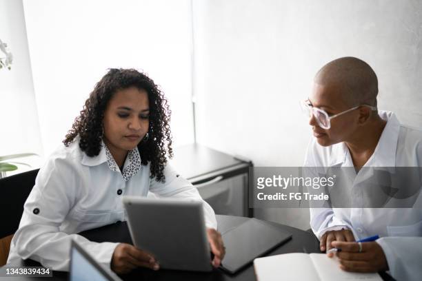 female doctors having a meeting in a hospital - bald 30s stockfoto's en -beelden