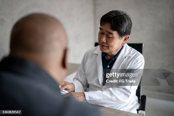 doctor talking to patient during medical appointment - eye doctor and patient stock pictures, royalty-free photos & images