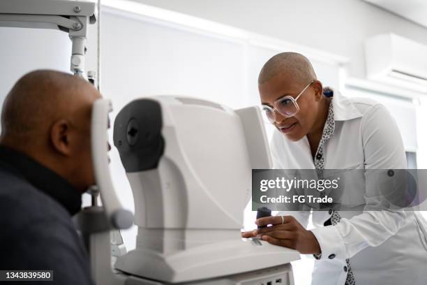 ophthalmologist examining patient's eyes - centro cirurgico imagens e fotografias de stock