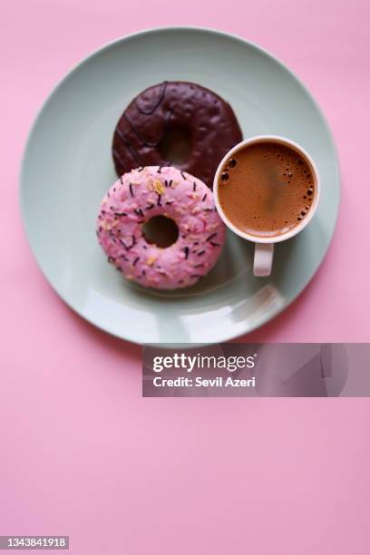 turkish coffee in a white cup and two donuts on a mint green round dessert plate on a candy pink background - mint green stock pictures, royalty-free photos & images