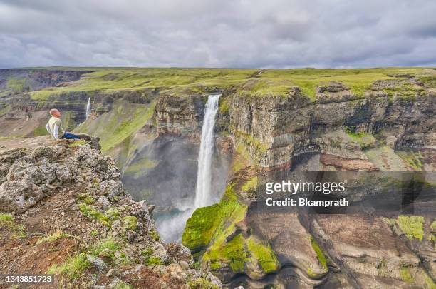 hiker enjoying the view of haifoss and granni waterfalls in the beautiful and unique island nation of iceland in europe - fossa river stock pictures, royalty-free photos & images