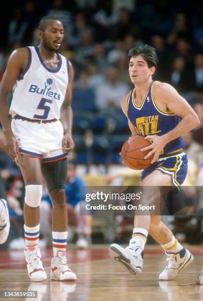 John Stockton of the Utah Jazz looks to pass the ball against the Washington Bullets during an NBA basketball game circa 1989 at the Capital Centre...