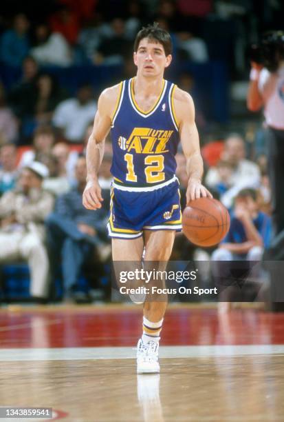 John Stockton of the Utah Jazz dribbles the ball up court against the Washington Bullets during an NBA basketball game circa 1989 at the Capital...