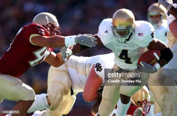 Ryan Grant of Notre Dame tries to get away from Josh Ott of Boston College during Boston College's 27-25 victory over Notre Dame at Alumni Stadium in...
