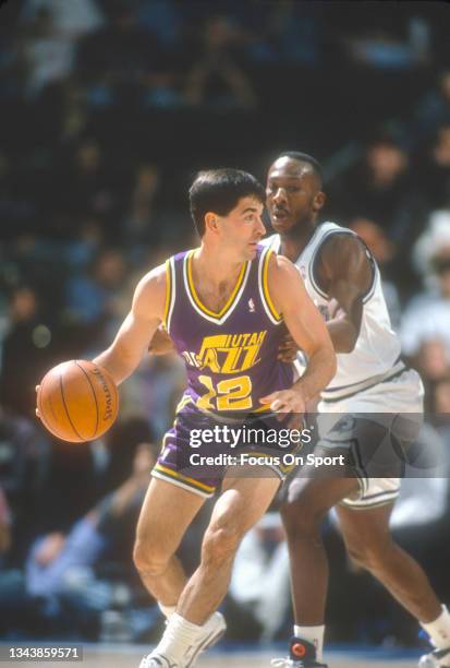 John Stockton of the Utah Jazz dribbling the ball is defended by Derek Harper of the Dallas Mavericks during an NBA basketball game circa 1993 at...