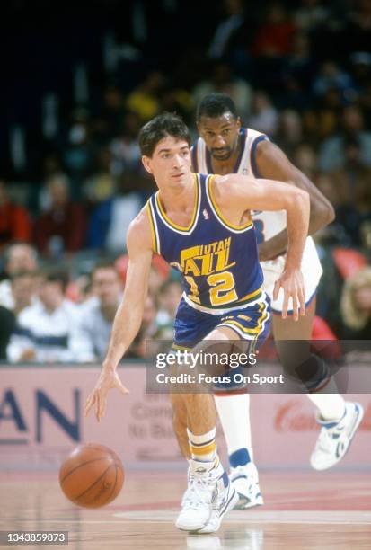 John Stockton of the Utah Jazz dribbles the ball up court against the Washington Bullets during an NBA basketball game circa 1989 at the Capital...