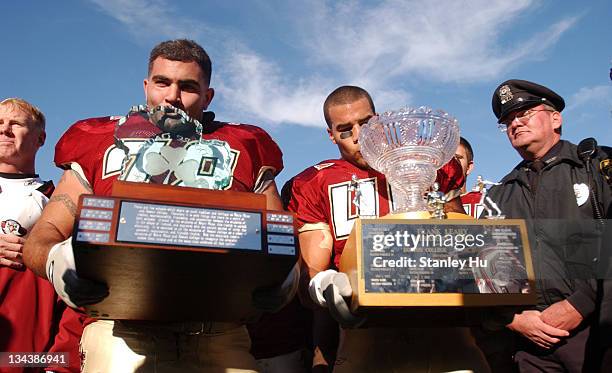 Augie Hoffman and Josh Ott of Boston College kiss their trophies after defeating Notre Dame 27-25 at Alumni Stadium in Newton, MA.