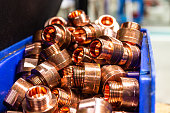 Copper metal, round shaft, golden brown, reflecting light, cut into pieces, with threads perforated through the mouth of the taper, stacked on top of each other.
