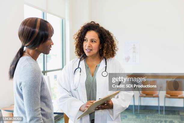 senior patientin und ärztin im mittleren erwachsenen besprechen testergebnisse - black female doctor stock-fotos und bilder