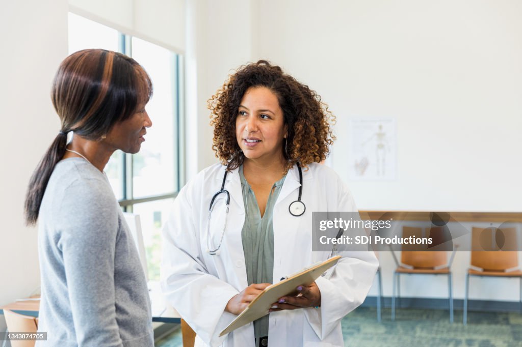 Senior female patient and mid adult doctor discuss test results
