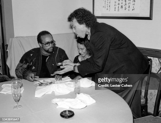 American record producer, musician, songwriter, composer, arranger, and film and television producer Quincy Jones looks on as American singer,...