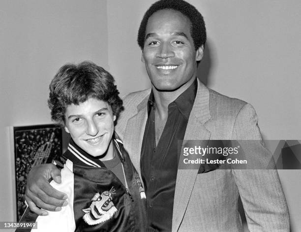 American former football running back, broadcaster, actor, advertising spokesman, and convicted felon O.J. Simpson poses for a portrait with a fan...