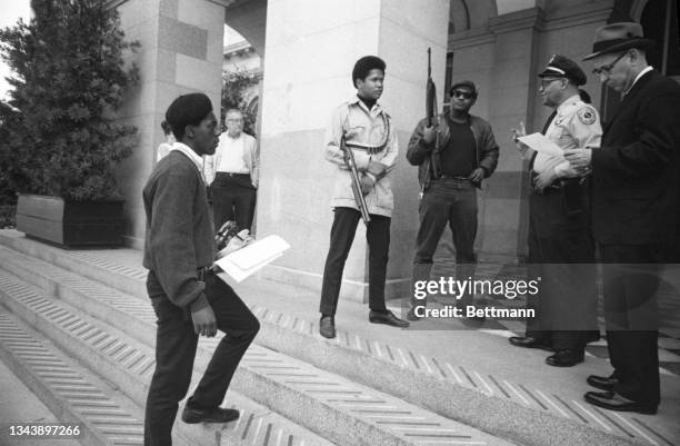 Two members of the Black Panther Party are met on the steps of the State Capitol in Sacramento, May 2 by Police Lt. Ernest Holloway, who informs them...