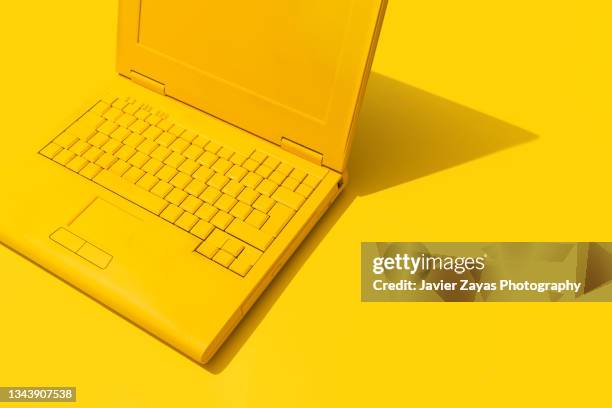 yellow laptop on yellow background - office work flat lay foto e immagini stock