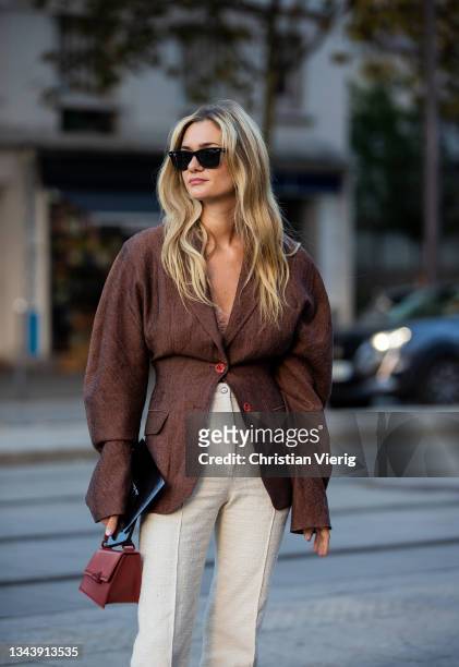 Anne-Laure Mais is seen wearing brown blazer, creme white pants, bag outside Acne during Paris Fashion Week - Womenswear Spring Summer 2022 on...