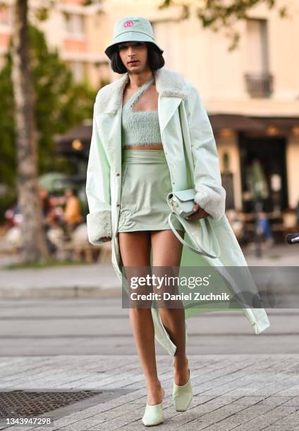 Guest is seen wearing a green coat, green top and skirt and Chanel hat outside the Acne show during Paris Fashion Week S/S 2022 on September 29, 2021...