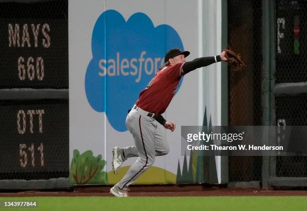 Jake McCarthy of the Arizona Diamondbacks runs down a fly ball to deny a hit by Donovan Solano of the San Francisco Giants in the bottom of the six...