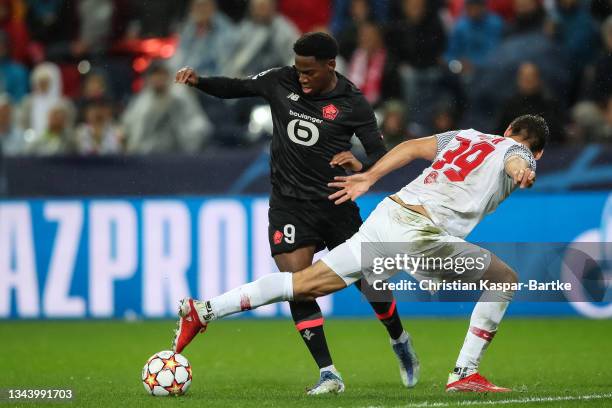 Jonathan David of Lille OSC is tackled by Maximilian Woeber of FC Red Bull Salzburg during the UEFA Champions League group G match between FC Red...