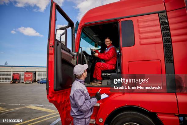 female truck driver talking to manager with clipboard - commercial land vehicle stock pictures, royalty-free photos & images