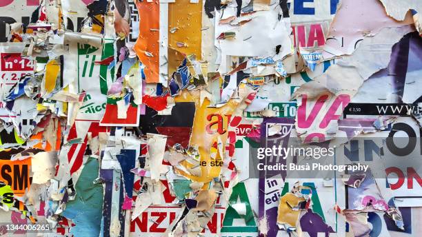 scratched layers of posters and placards on wall in the streets of florence, italy - advertisement foto e immagini stock