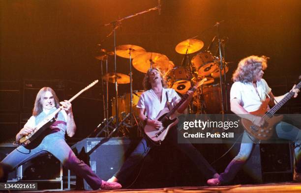 Francis Rossi, Rick Parfitt and Alan Lancaster of Status Quo perform on stage at Hammersmith Odeon on March 14th, 1981 in London, United Kingdom.