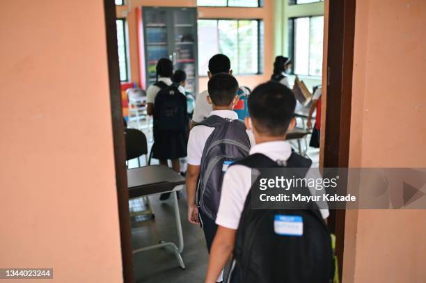 rear view of school children with schoolbags entering the classroom - indian society and daily life ストックフォトと画像