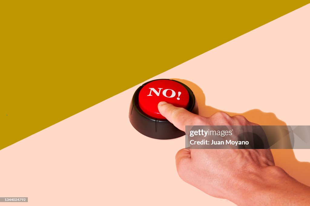 Man pushing a red button with the word no