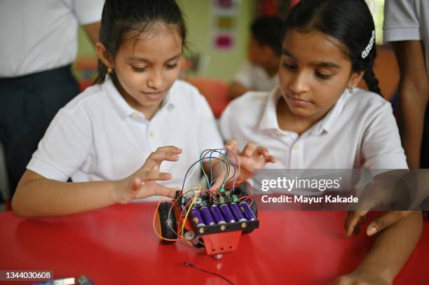 school girls making wiring connections in a robot model car in school - remote control car stock pictures, royalty-free photos & images