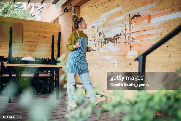 female painter painting on wall - hair bun stockfoto's en -beelden