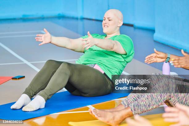 woman sitting on the floor at a yoga class - balding stock pictures, royalty-free photos & images