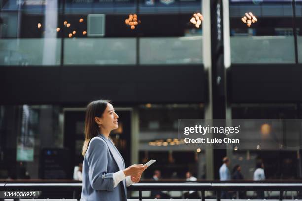 business on the go - asian females on a phone imagens e fotografias de stock