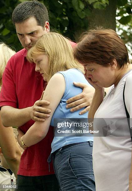People weep as they look at flowers and messages left in remembrance of Holly Wells and Jessica Chapman outside St Andrew's Church August18, 2002 in...