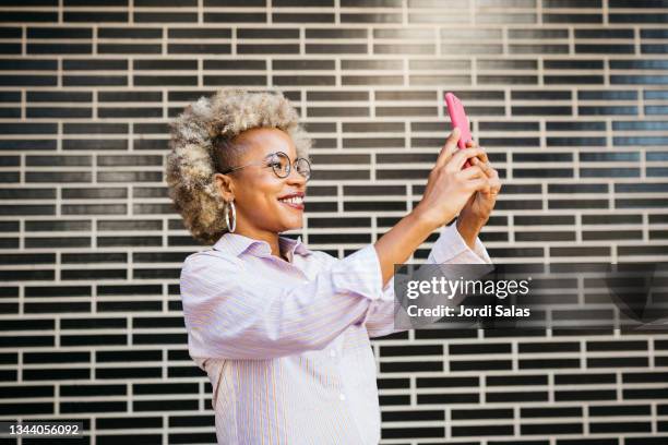 woman using an smart phone - blonde woman selfie foto e immagini stock