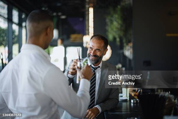 geschäftsleute reden und trinken an der bar. - business cocktail stock-fotos und bilder