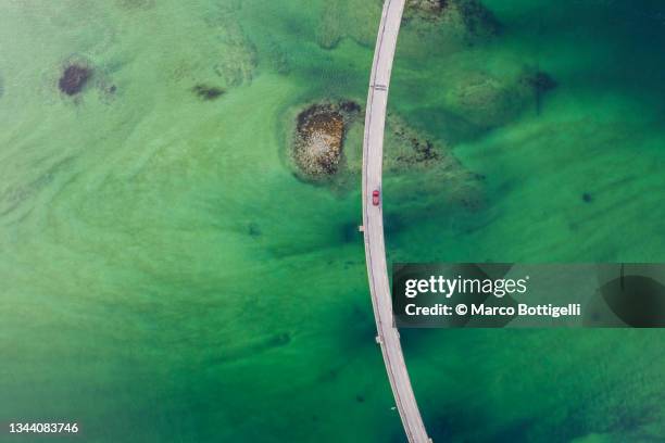 car drive on bridge over emerald green water - insel senja stock-fotos und bilder